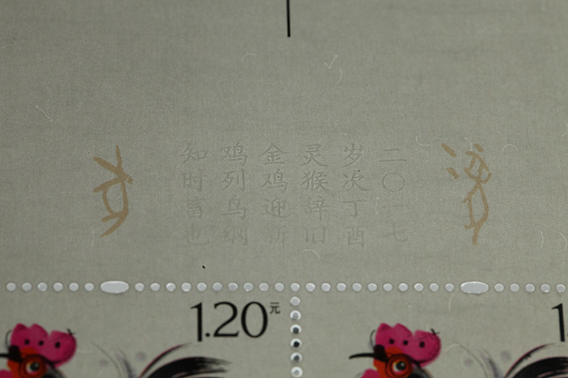2017-1《丁酉鸡》（版张边饰中的生肖文字信息，使用的是无墨雕刻，呈现出雕刻版印文凸出纸面却无墨迹的效果。字迹清晰隽秀，立体效果明显）